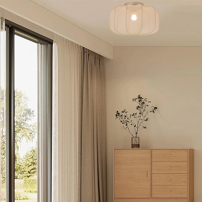 Plafondlamp met subtiele textiele kap die rust en warmte brengt in woonkamer of slaapkamer.