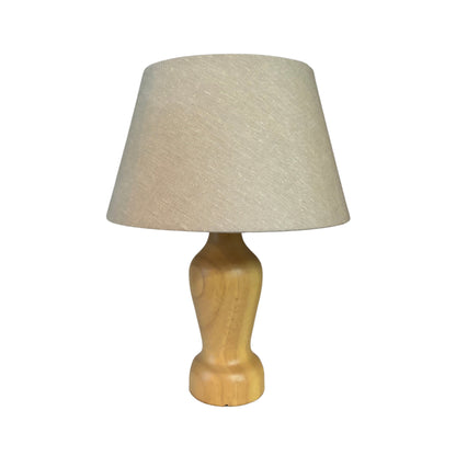 Tafellamp Mona met een lichtgekleurde houten voet en een zandkleurige linnen kap tegen een witte achtergrond.