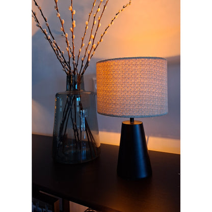 Bijzondere detailfoto van de Faro tafellamp in zand en zwart. Deze lamp voegt een warme sfeer toe aan elk interieur.