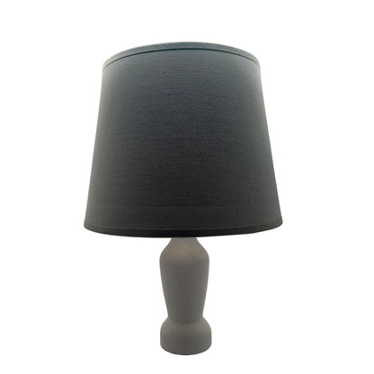 Een grijze lampenkap in een sfeervolle setting. Deze stijlvolle kap brengt een warme uitstraling in elke kamer.