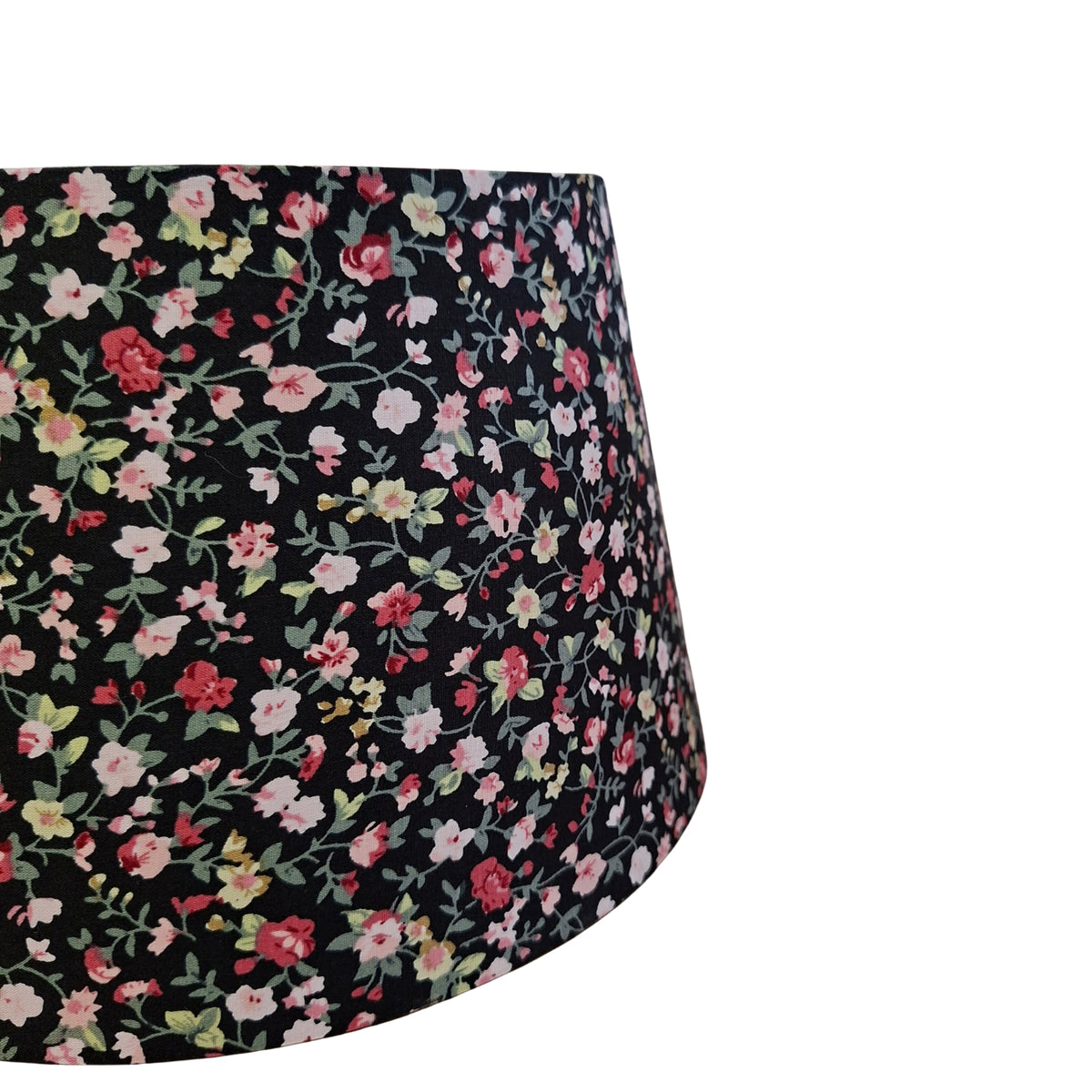 Een zwarte lampenkap met bloemenprint in chintz-stijl, ideaal voor een bohemian vintage uitstraling in je interieur.
